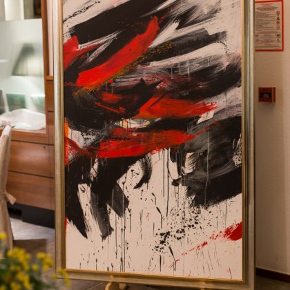 Abstraktna slika s motivi bele, rdeče in črne barve.